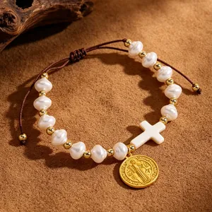 Close-up of handmade pearl bracelet with cross and Saint Benedict medal