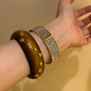 Vintage wooden studded bracelet paired with a sparkly gold rhinestone bangle for women
