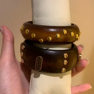 Vintage style wide wooden bracelets with gold rivets and intricate engraved floral metal detail