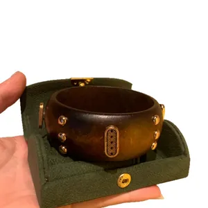 Handcrafted vintage dark wood wide bangle with gold rivets and engraved detail in green box