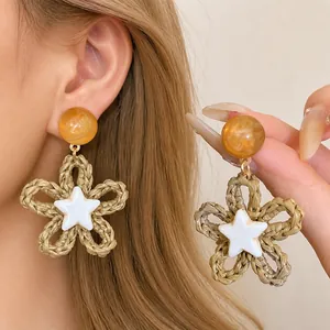 Woven flower drop earrings featuring a white star center for beach resort style
