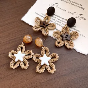 Detail of straw woven flower earrings with wood star pendant and resin beads