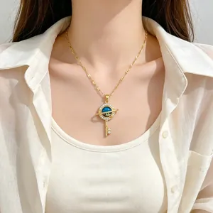 Elegant gold titanium steel necklace with planet key pendant worn by a model.