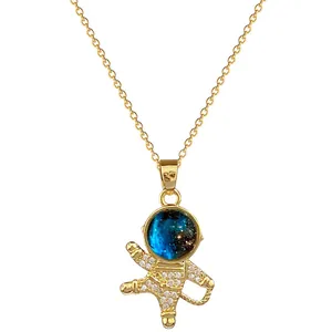 Close-up of golden astronaut pendant featuring a blue galaxy stone and crystals