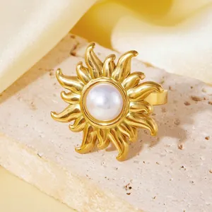 Detailed view of an 18K gold-plated sunburst ring featuring a central white pearl inlay.