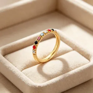 Gedetailleerde close-up van een 3mm gouden titanium stalen ring met gekleurde zirkoonstenen