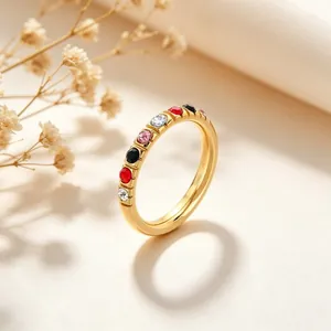 Detailopname van een 3mm gouden titaniumstalen ring met veelkleurige zirkonia steentjes