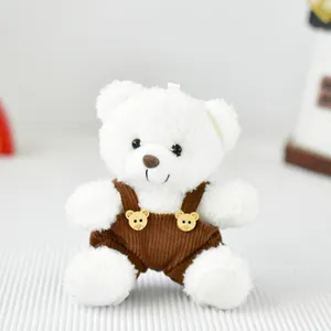 Vista dettagliata di un morbido orsetto di peluche bianco con una graziosa salopette marrone
