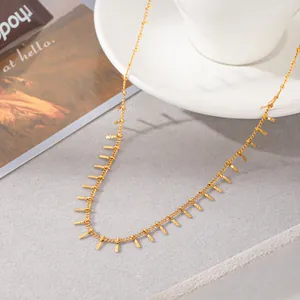 Close-up detail of a minimalist gold-plated fringe necklace with hanging metal bars.