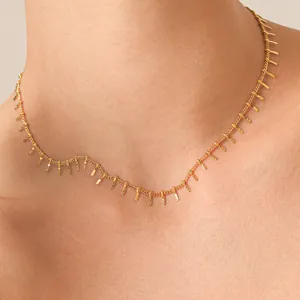 Close-up of elegant gold stainless steel choker with delicate fringe tassel detail.