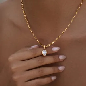 Détail d'un pendentif en zircone en forme de poire sur une chaîne dorée en acier inox