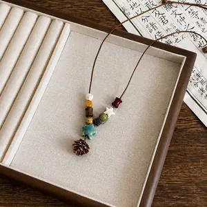 Dettaglio di una collana stile etnico vintage con perle di legno e un ciondolo a stella in ceramica