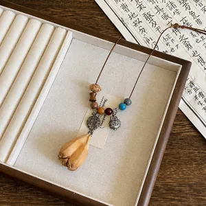 Vista dettagliata di una collana vintage etnica con ciondolo in legno e perle