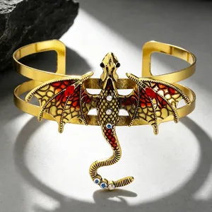 Nahaufnahme eines vintage goldfarbenen Drachen-Armreifs mit detaillierten bunten Emailleflügeln