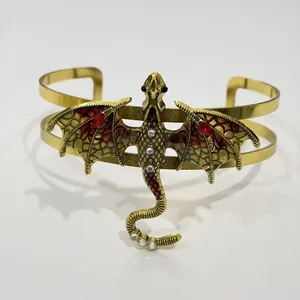 Nahaufnahme einer Vintage-Drachenbrosche mit farbenfrohen rot-goldenen Emaille-Flügeln