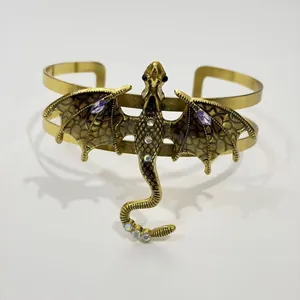 Nahaufnahme einer Vintage Drachenbrosche mit braunen Emaille Flügeln und Kristallen