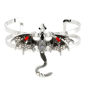 Detailansicht einer silbernen Drachenbrosche im Vintage-Stil mit roten Glassteinen.