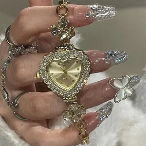 Close-up of elegant gold heart-shaped watch with rhinestone clover bracelet strap