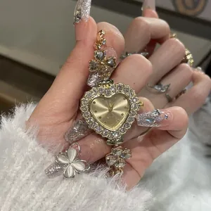 Close-up of luxury gold heart-shaped rhinestone watch with floral bracelet strap on hand