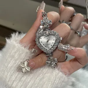 Close-up of elegant heart-shaped quartz watch with clover rhinestone bracelet worn on wrist