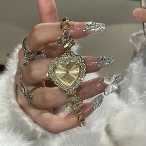 Detailed view of luxury heart-shaped gold watch with sparkling rhinestone flower bracelet
