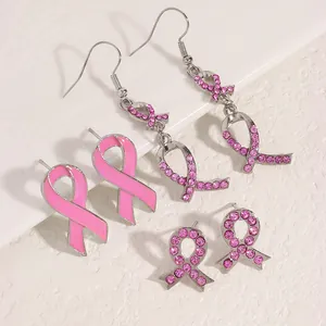 Detailansicht von rosa Schleifen-Ohrringen mit Strasssteinen zur Brustkrebs-Vorsorge.