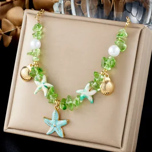 Macro detail of green stone beaded necklace with starfish and shell charms for holiday.