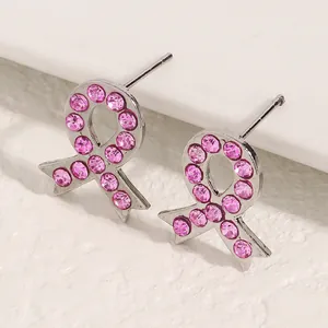 Nahaufnahme von Ohrringen mit rosa Schleife für das Brustkrebs-Bewusstsein.