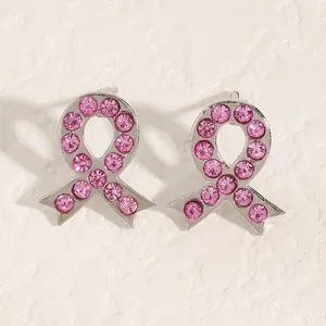 Detailansicht der silberfarbenen Ohrringe mit rosa Schleife und Strasssteinbesatz.