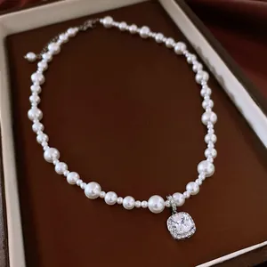 Detailansicht der strukturierten Perlen und des funkelnden quadratischen Anhängers dieser Kette