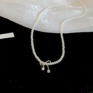 Elegante Perlenkette im französischen Stil mit zartem Schleifenanhänger und funkelndem Zirkon.