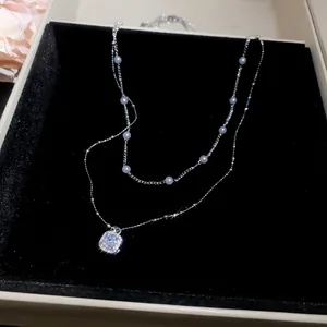 Detailansicht einer französischen Doppel-Halskette mit Perlen und quadratischem Diamant.