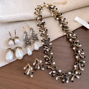 Detailed view of vintage gold-tone geometric necklace and pearl earring set jewelry