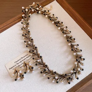 Detailed view of vintage gold-tone necklace and earring set with pearls and black beads