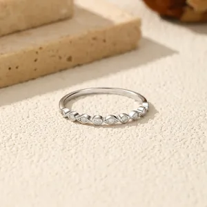 Elegante anillo de plata de ley S925 con moissanita geométrica engastada sobre fondo de arena