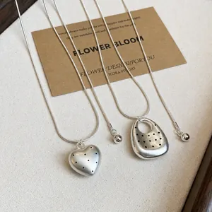 Minimalistisches Silberhalsketten-Set mit Herz- und Kieselanhängern mit schwarzen Punkten