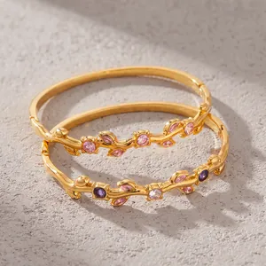 Close-up view of gold-plated branch bangles with sparkling colorful zircon inlays.
