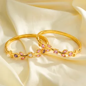 Close-up of gold-plated branch design bracelets with pink and purple zircon inlays.