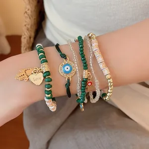Close-up of bohemian beaded bracelet set with evil eye and heart charms on wrist