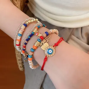 Close-up of bohemian beaded bracelet set with evil eye and heart charms on wrist