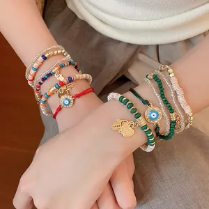 Close-up of bohemian beaded bracelet set with evil eye and hamsa hand charms on wrist
