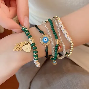Detailed view of bohemian layered beaded bracelet set featuring evil eye and hamsa charms
