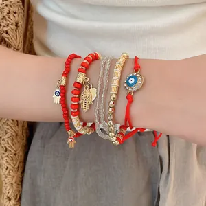 Detailed view of evil eye and hamsa hand charms on multi-layered beaded bracelet set