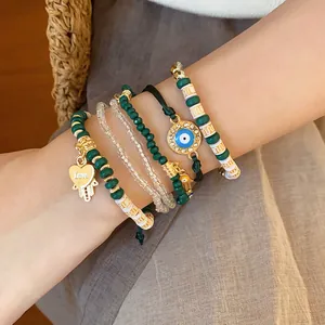 Close-up of vintage beaded bracelet set with heart and evil eye charms on wrist