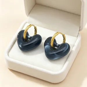 Vintage oorbellen met gemarmerde hars hartjes en gedraaide gouden titanium stalen ringen.