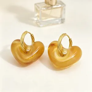 Gedetailleerd beeld van vintage amberkleurige hart oorbellen met gouden hoops