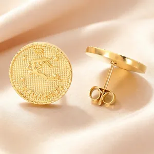 Macro view of the embossed Aquarius zodiac detail on a vintage golden coin earring.
