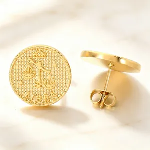 Macro view of vintage gold plated Libra zodiac relief coin stud earrings in stainless steel