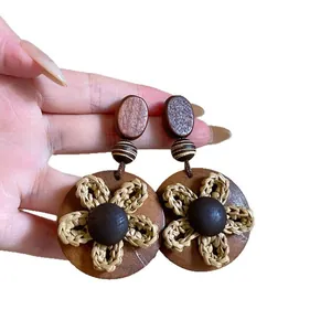 Retro etnische houten oorbellen met handgeweven strooien bloemdetails en vintage bohemien look.
