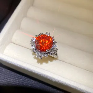 Makroansicht eines eleganten blumenförmigen Rings mit leuchtend orangem Zirkon-Zentrum